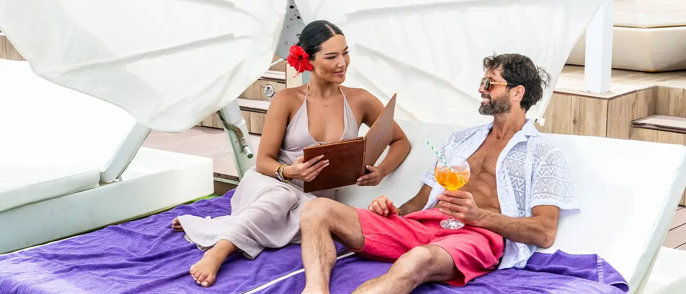 A couple reading and relaxing on sun loungers